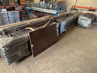a large pile of metal in a warehouse with a lot of pallets