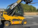 a man standing next to a yellow forklift truck
