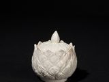 a white vase that is sitting on a black surface