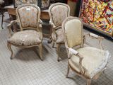 several chairs and a table in a room with a painting on the wall