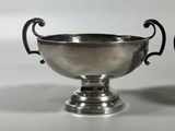pair of silver plated bowls with handles and handles on a white surface