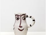 an image of a ceramic mug with a face painted on it