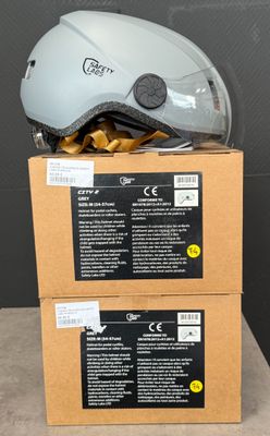 deux cartons posés sur une table, avec des casques posés dessus