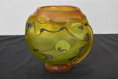 a yellow vase sitting on a table with a black table cloth