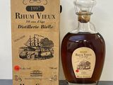 une image représentant une bouteille de rhum devant une boîte