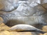a white purse that is sitting on a bed