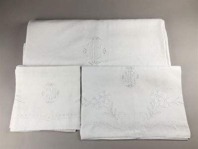 quatre serviettes de table en lin blanc ornées de monogrammes brodés