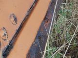 a close up of a rusted piece of machinery in the grass