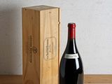 une bouteille de vin à côté d'une caisse en bois sur une table