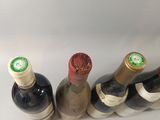 several bottles of wine are lined up on a white surface