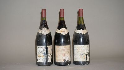 trois bouteilles de vin sont alignées sur une table
