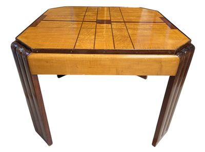 La table est en bois et présente un motif géométrique.