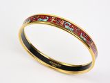 un gros plan sur un bracelet rigide en émail rouge et noir