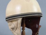 une image représentant un casque posé sur un socle en bois, sur fond gris