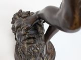 bronze statue of a man with a beard and a hand on a base