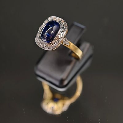 un gros plan d'une bague sertie d'un saphir et de diamants
