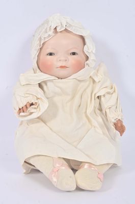 a baby doll that is sitting on a white surface