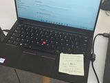 un ordinateur portable posé sur une table, entouré de nombreux câbles