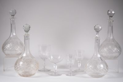 des bouteilles et des verres sont alignés sur une surface blanche