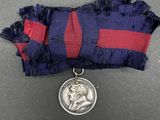 an image of a medal with a silver medal on a ribbon