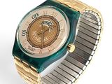 a gold and green watch with a white face