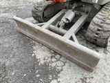 a tractor with a plow attachment attached to the back of it