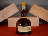 a bottle of liquor sitting on a table next to a wooden box