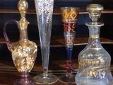 Plusieurs vases en verre sont posés sur une étagère dans une pièce