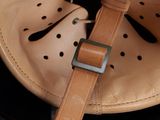 a baseball helmet with a leather strap on it