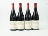 quatre bouteilles de vin sont alignées sur une surface blanche