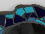 a mirror that has a blue and black mosaic design on it