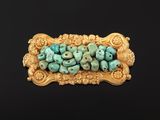 a close up of a gold and turquoise beaded broochle