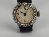 a close up of a wrist watch with a diamond bezeled face