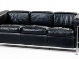 a black leather couch sitting on a white surface