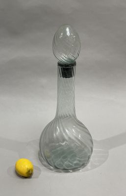 a glass bottle and a lemon sitting on a table