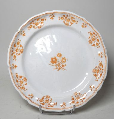 une assiette blanche ornée de fleurs orange, posée sur une table