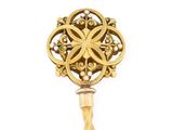 an image of a gold and green broochle on a stick