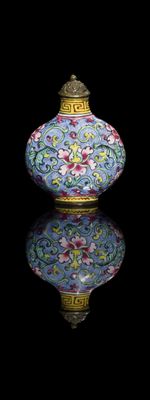 a blue vase with flowers on it on a black surface