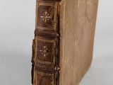 an old book sitting on top of a white surface