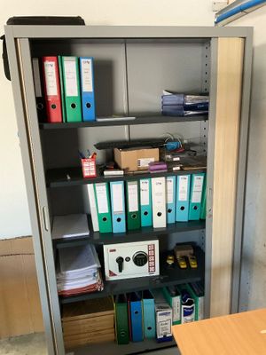 une armoire métallique sur laquelle se trouvent de nombreux dossiers et chemises