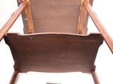 a wooden rocking chair with a wooden seat and a book