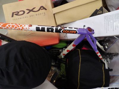 a pile of assorted sports equipment on a bed