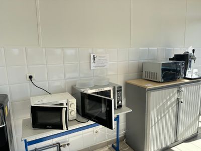 two microwaves sitting on top of a counter in a kitchen