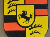un gros plan de l'emblème Porsche sur un mur