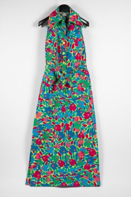 a colorful dress hanging on a hanger against a white wall