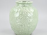 a green vase sitting on a table with a white background