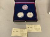 two silver coins are in a purple box on a table