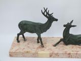 statue of a pair of deer on a marble base on a white background
