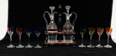 Plusieurs verres à vin et une carafe sont alignés sur une table
