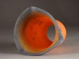 an orange and blue vase sitting on a table